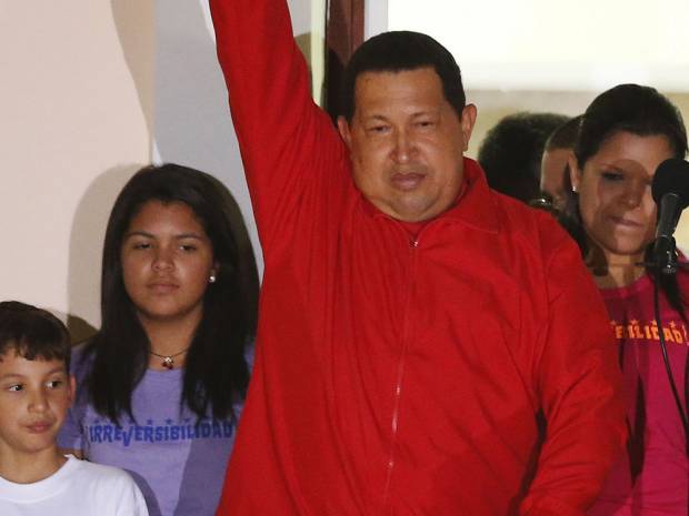 Venezuelan President Hugo Chavez celebrates from a balcony at Miraflores Palace in Caracas