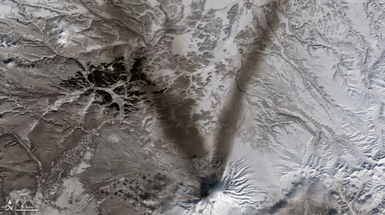 La letra “v” es una imagen de la ceniza expulsada por el volcán Shiveluch, en la península rusa de Kamchatka que contrasta con la nieve a su alrededor. Imagen tomada por el Landsat 8.