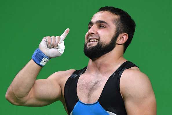 Kazakhstan's Nijat Rahimov celebrates after he won the Men's 77kg weightlifting competition at the Rio 2016 Olympic Games in Rio de Janeiro on August 10, 2016. / AFP / GOH Chai Hin (Photo credit should read GOH CHAI HIN/AFP/Getty Images)