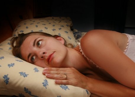 Mujer en una cama despierta