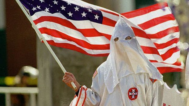 Miembro del Ku Kux Klan con bandera de Estados Unidos