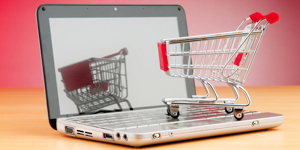 Laptop con carrito de compra de supermercado