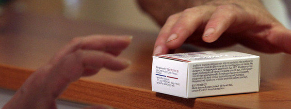 Close up de manos con caja de medicamento