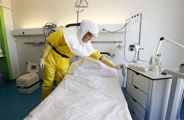 sanitario en traje ébola prepara cabina médica