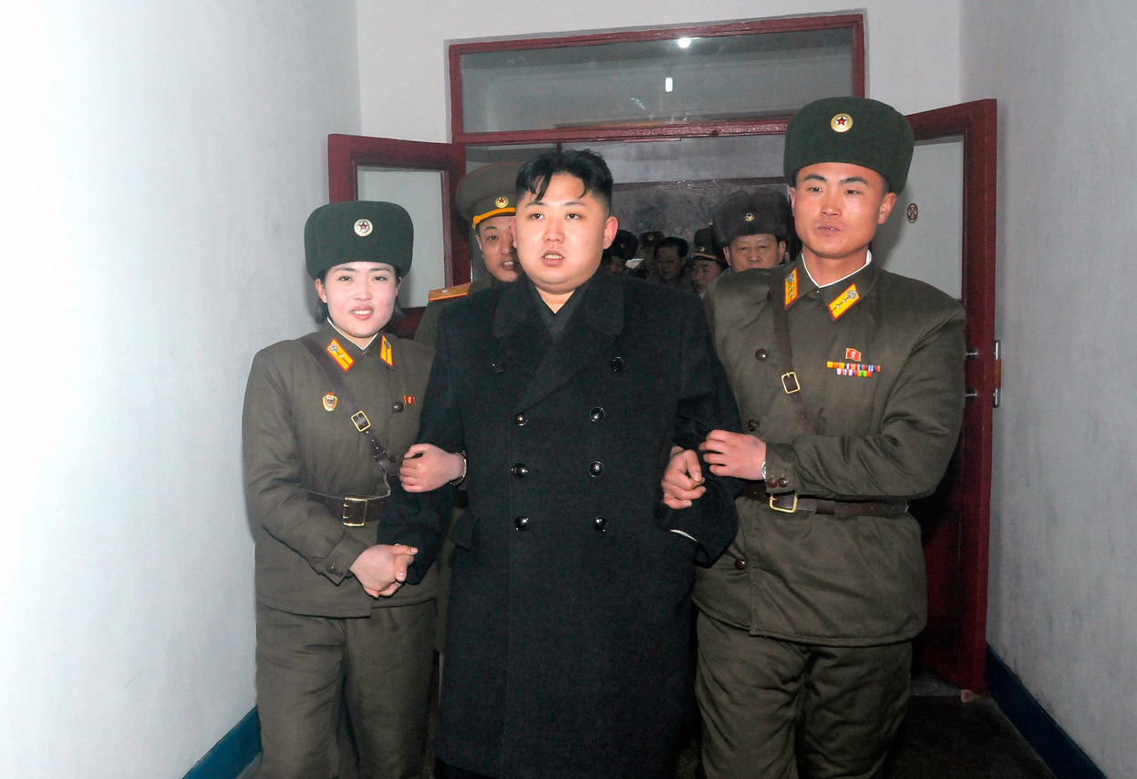 Kim Jong-un ayudado por asistentes